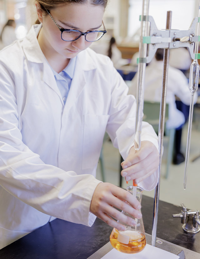 Student using beaker inside Cerdon College Merrylands science labs