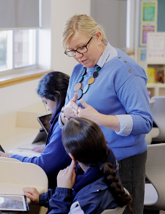 Teacher helping student at Cerdon Catholic College Merrylands