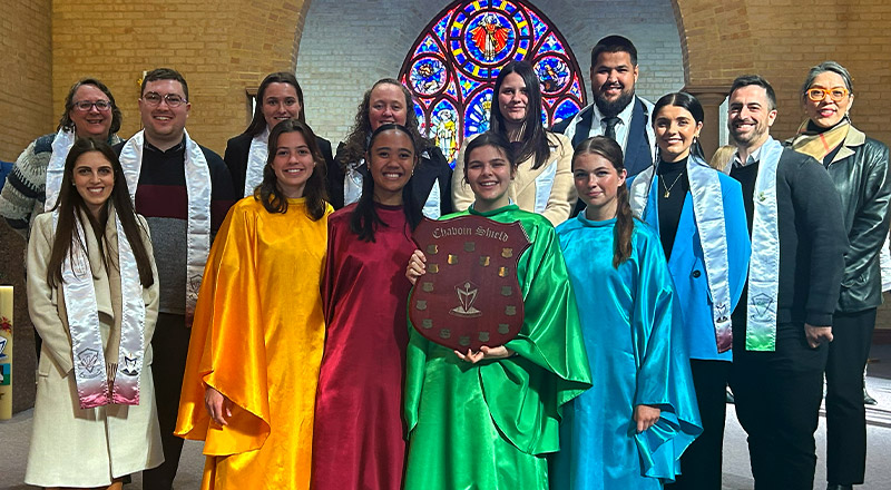 Cerdon Catholic College Merrylands students and teachers in bright colours holding large badge