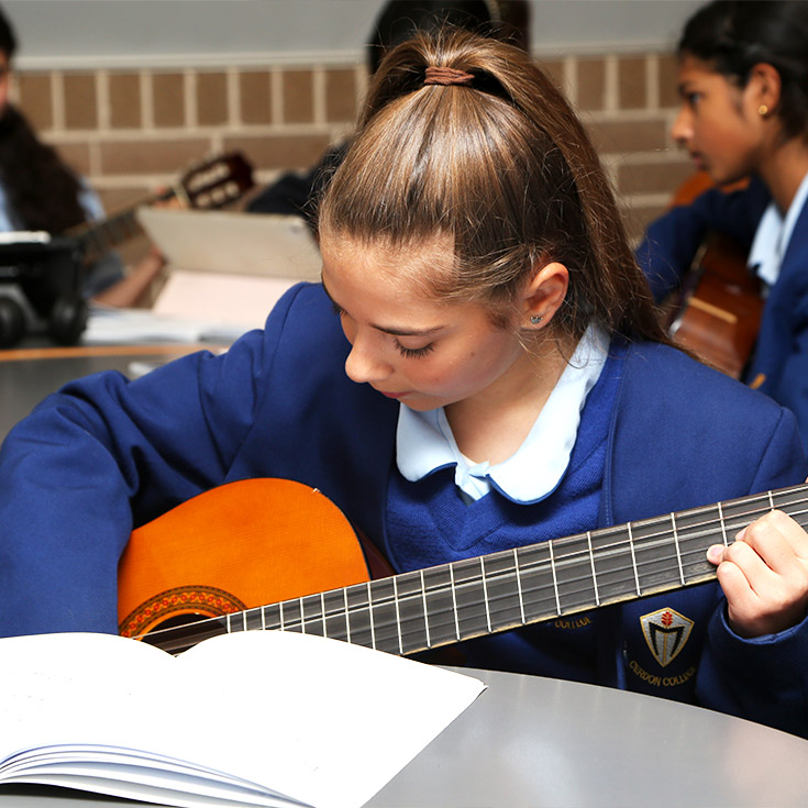 Student learning guitar at Cerdon College Merrylands