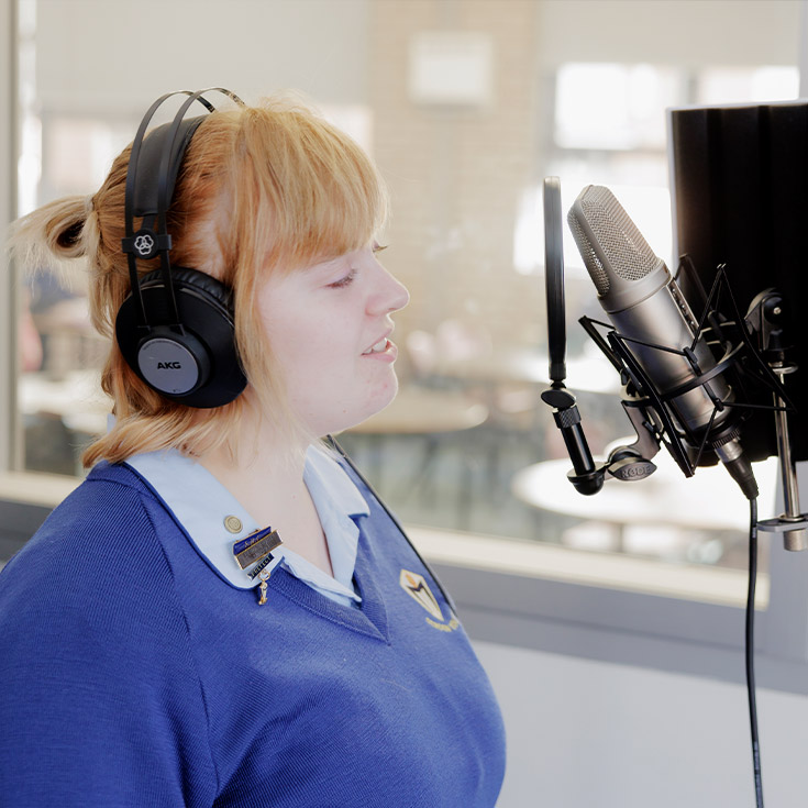 Student inside audio booth at Cerdon College Merrylands