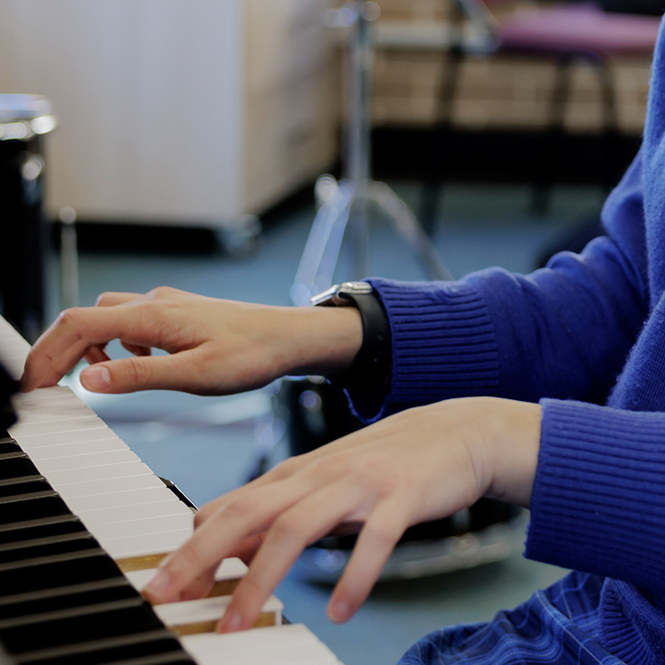 Close up shot of students hands playing piano at Cerdon College Merrylands